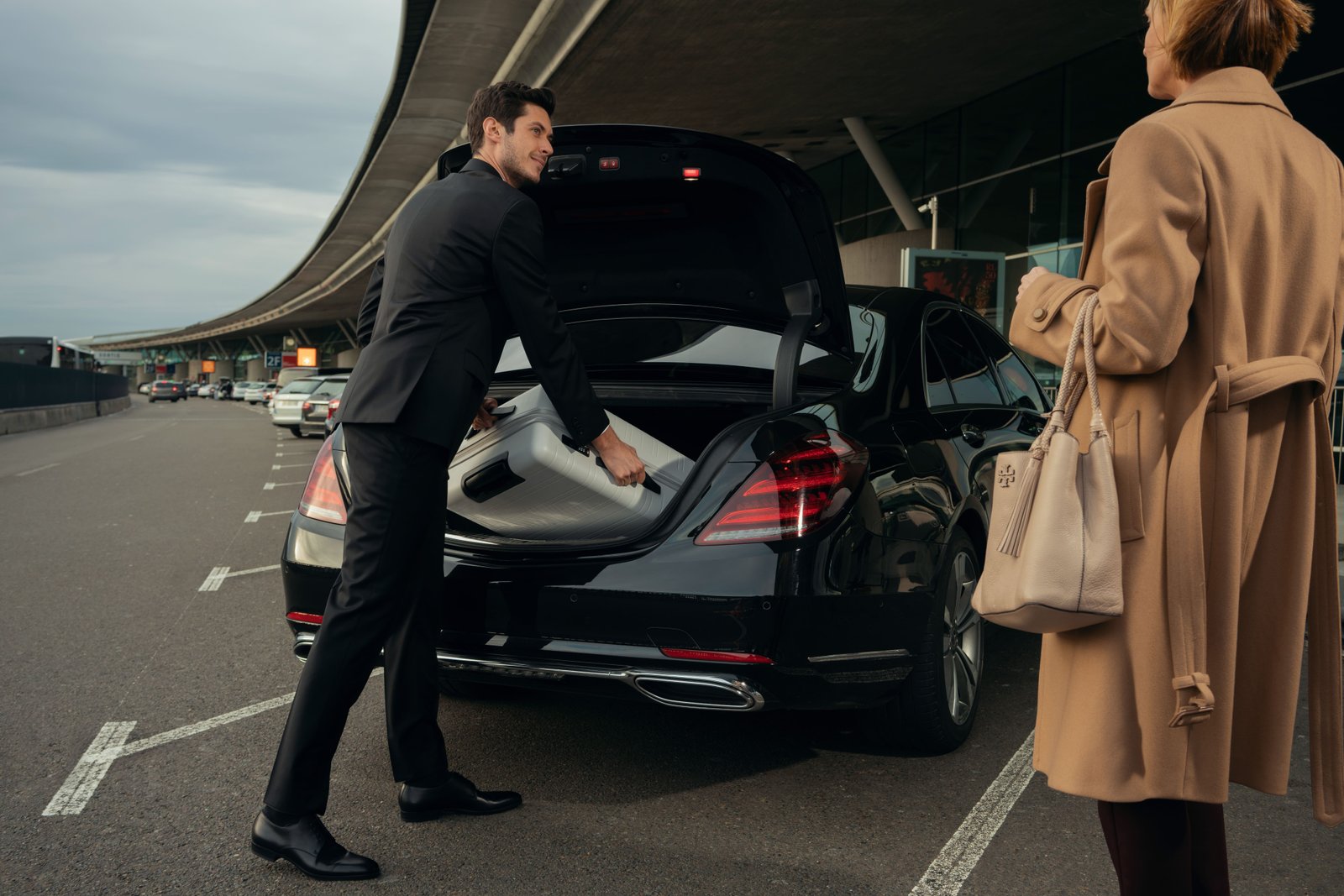 Image of a car being loaded with luggage and a family standing nearby